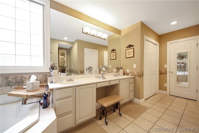 bathroom with recessed lighting, a sink, tile patterned floors, a tub, and double vanity