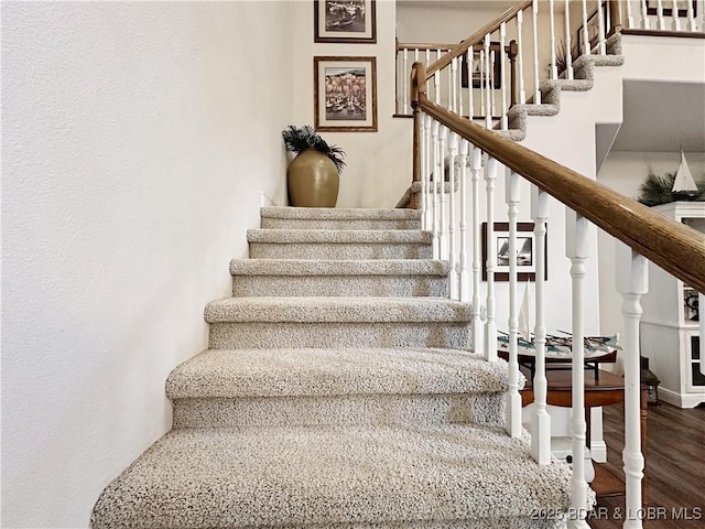 stairs featuring wood finished floors and baseboards