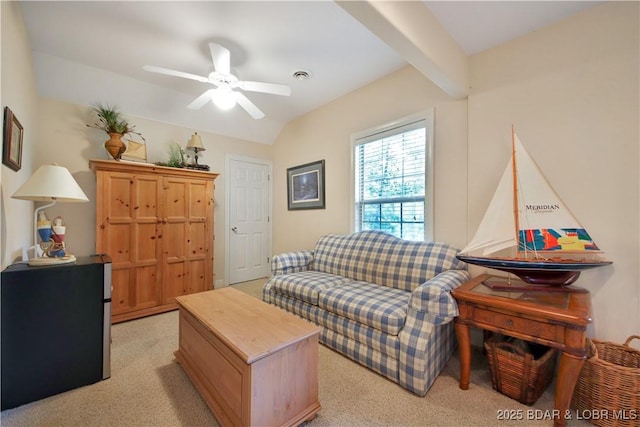 sitting room featuring a ceiling fan and beamed ceiling