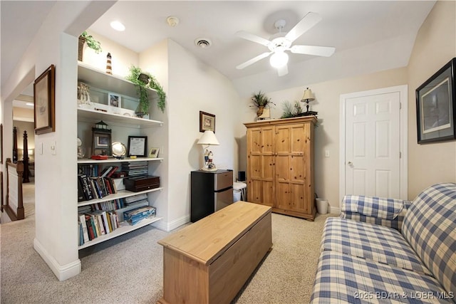 living area with lofted ceiling, light carpet, a ceiling fan, visible vents, and baseboards