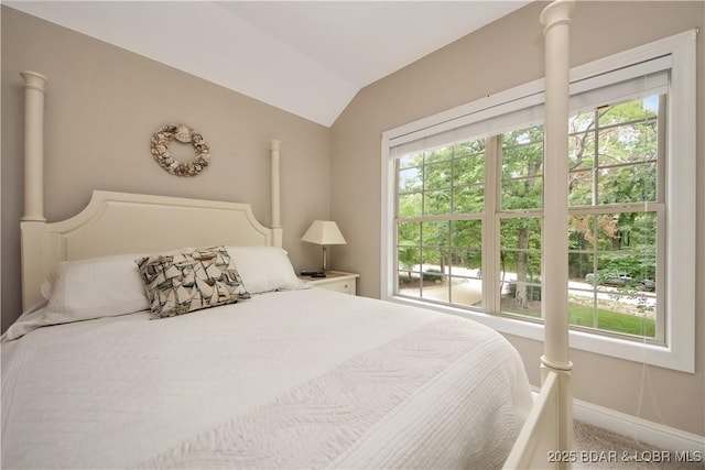 bedroom featuring decorative columns, baseboards, and vaulted ceiling