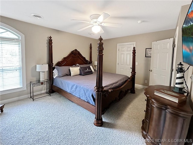 carpeted bedroom featuring a ceiling fan, visible vents, and baseboards