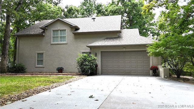 traditional-style house featuring a garage, driveway, a shingled roof, and stucco siding