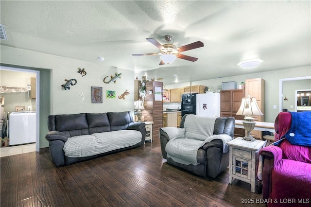 living room with washer / clothes dryer, visible vents, ceiling fan, a textured ceiling, and hardwood / wood-style floors