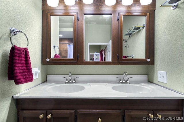 bathroom featuring a textured wall, double vanity, and a sink