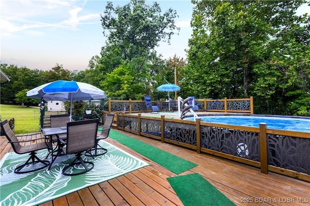 deck with outdoor dining area and an outdoor pool