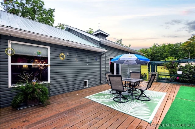 deck at dusk with outdoor dining space