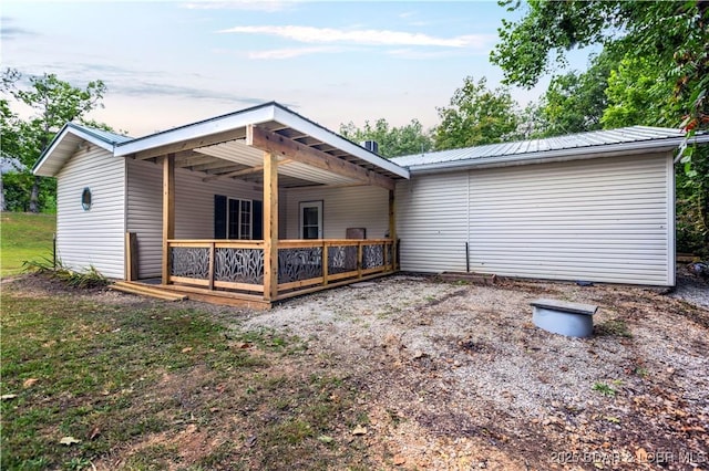 back of house featuring a deck and metal roof