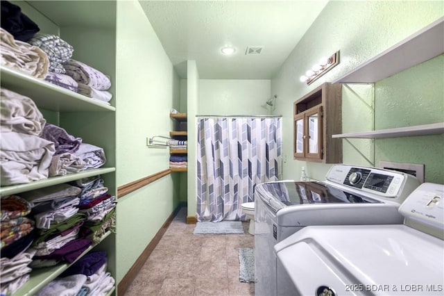 laundry area with laundry area, visible vents, independent washer and dryer, and baseboards