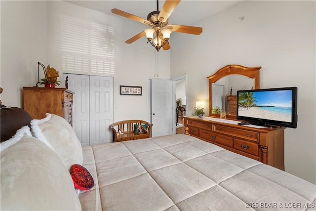 bedroom featuring a ceiling fan, a closet, and a high ceiling