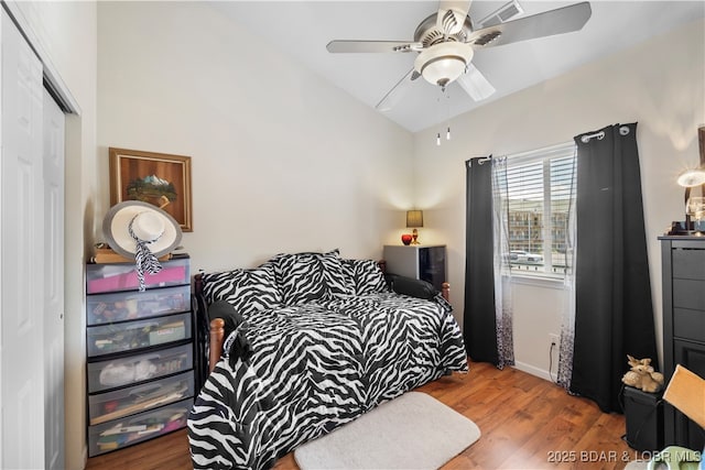 bedroom featuring ceiling fan, a closet, vaulted ceiling, and wood finished floors