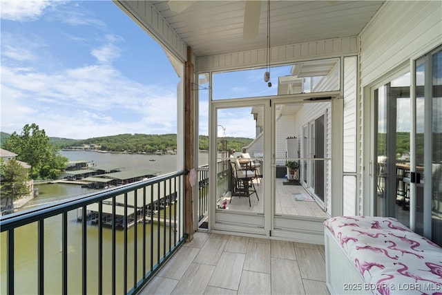 balcony featuring a water view and a sunroom