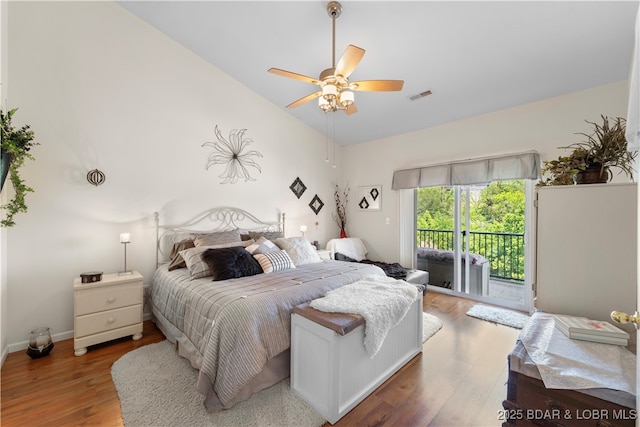 bedroom with lofted ceiling, visible vents, a ceiling fan, wood finished floors, and access to outside