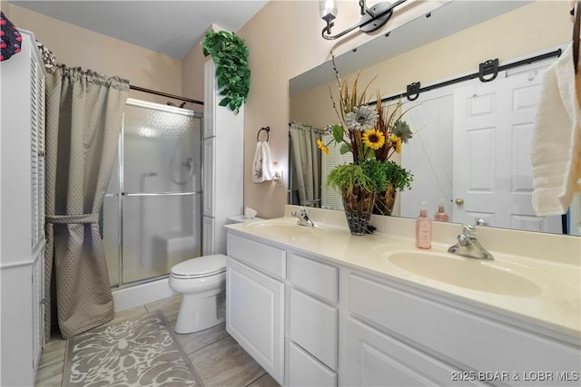 bathroom featuring double vanity, a stall shower, a sink, and tile patterned floors