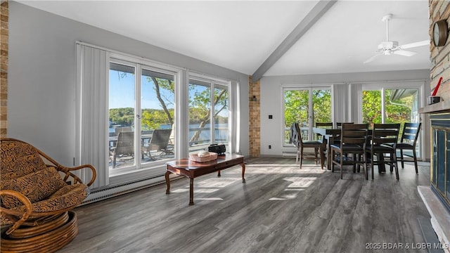 sunroom / solarium with a wealth of natural light, a baseboard radiator, ceiling fan, and vaulted ceiling with beams