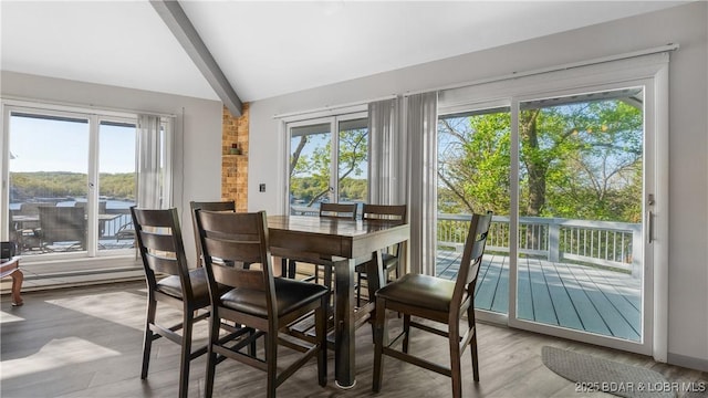 dining space featuring vaulted ceiling with beams and wood finished floors