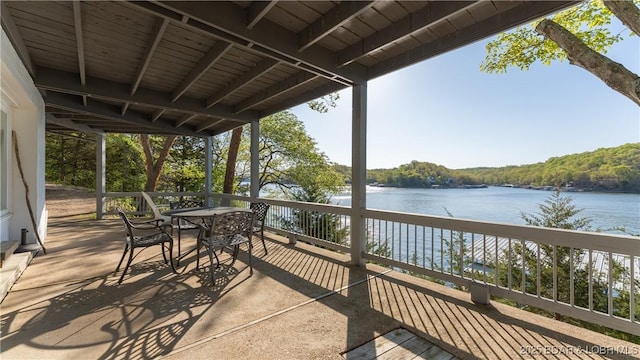 view of patio with outdoor dining area and a water view