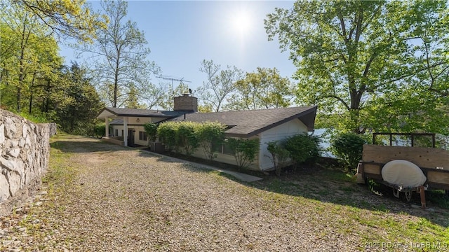 exterior space featuring a front lawn and a chimney