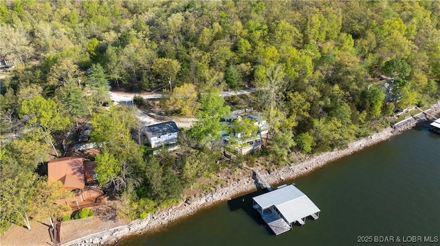 aerial view featuring a forest view and a water view