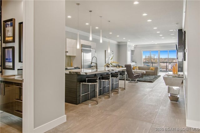 kitchen with modern cabinets, recessed lighting, a breakfast bar area, white cabinets, and light countertops