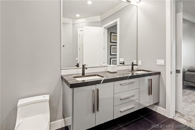 bathroom with double vanity, toilet, crown molding, and a sink