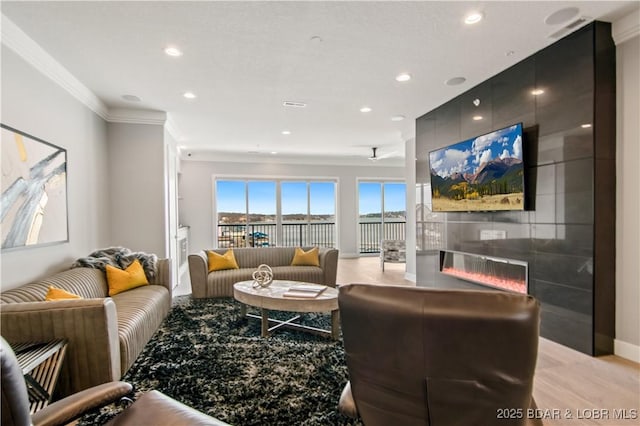 living room with crown molding, recessed lighting, a fireplace, and baseboards