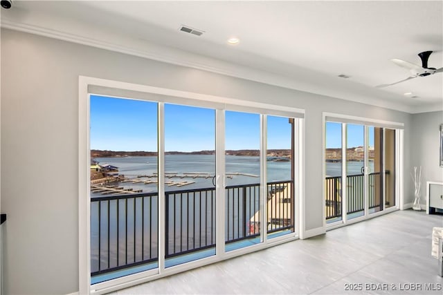 unfurnished sunroom featuring visible vents, a ceiling fan, and a water view