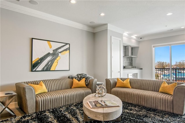 living area with recessed lighting and ornamental molding