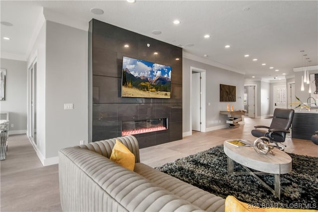 living room featuring recessed lighting, a fireplace, baseboards, and ornamental molding