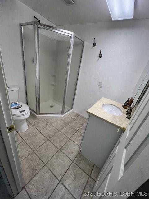 bathroom with vanity, a shower stall, toilet, and tile patterned floors