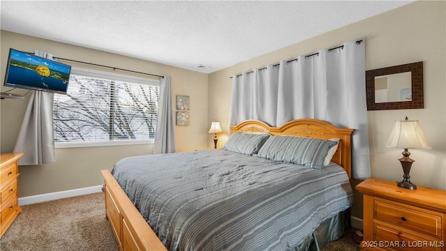 bedroom with a textured ceiling, carpet flooring, and baseboards