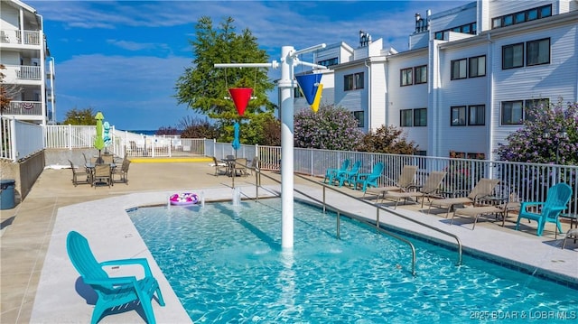 community pool with a patio area and fence