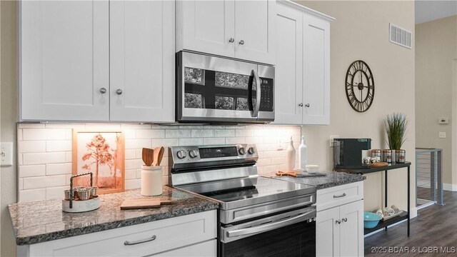 399 W End Cir, Osage Beach, MO 65065 - kitchen with stainless steel appliances, backsplash, white cabinetry, dark wood-style flooring, and dark stone countertops