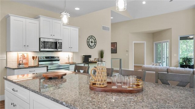 399 W End Cir, Osage Beach, MO 65065 - kitchen featuring appliances with stainless steel finishes, light stone counters, decorative backsplash, white cabinetry, and hanging light fixtures