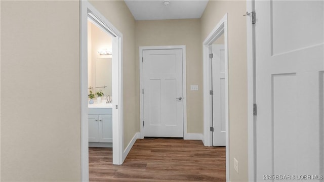 hallway with baseboards and wood finished floors