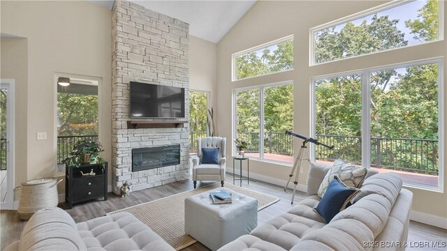 399 W End Cir, Osage Beach, MO 65065 - living room with high vaulted ceiling, a fireplace, and wood finished floors