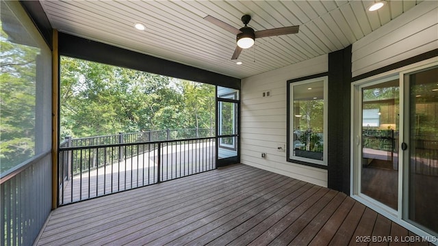 unfurnished sunroom featuring wood ceiling and a ceiling fan