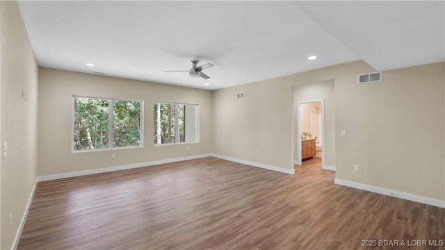 unfurnished room with a ceiling fan, baseboards, visible vents, and wood finished floors