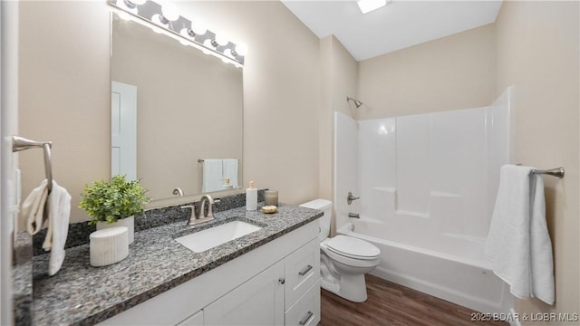 full bathroom featuring vanity, bathing tub / shower combination, wood finished floors, and toilet