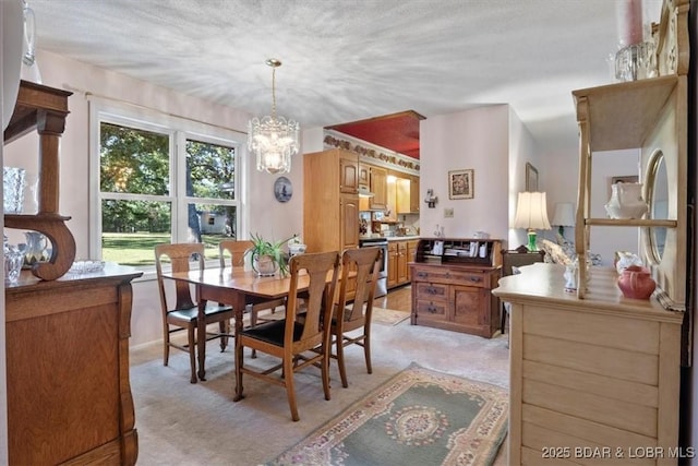 dining space featuring light colored carpet and a notable chandelier