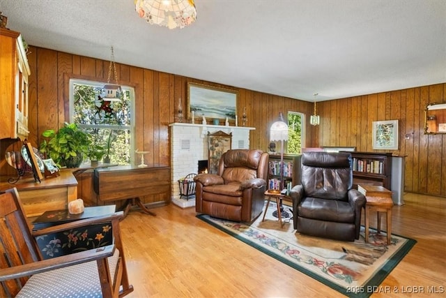 living area featuring a brick fireplace, wood finished floors, and wood walls