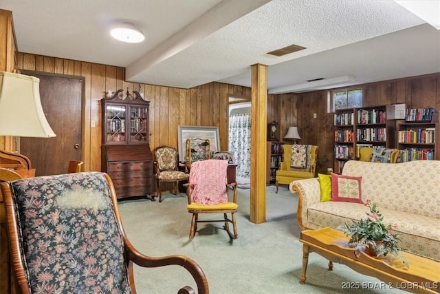 living area featuring visible vents, wooden walls, and carpet flooring