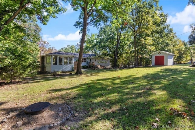 view of yard with a storage shed, a detached garage, and an outbuilding