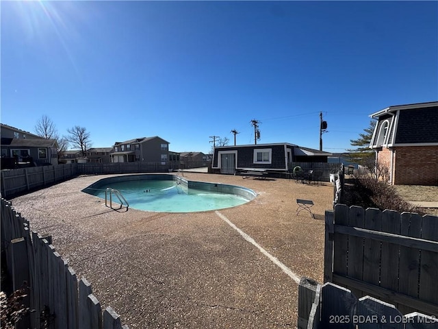 view of swimming pool featuring a patio area, a fenced backyard, a fenced in pool, and an outbuilding