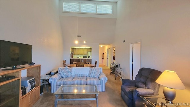 carpeted living room featuring a towering ceiling and visible vents