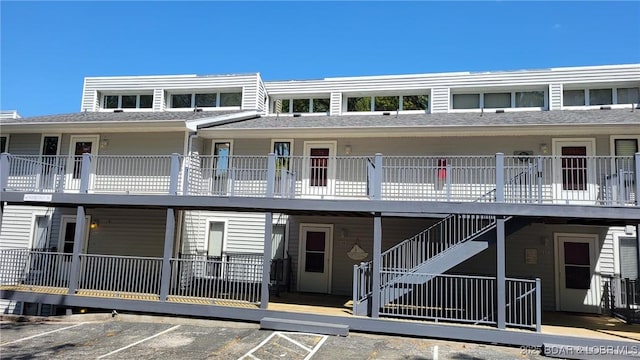 view of property featuring stairs and uncovered parking