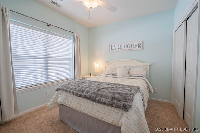 carpeted bedroom with ceiling fan, a closet, visible vents, and baseboards