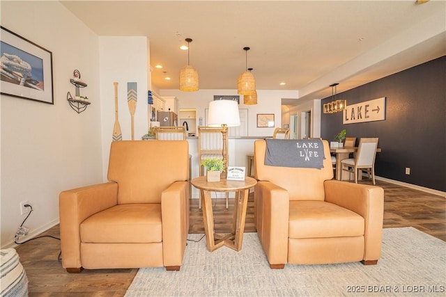 sitting room with baseboards, wood finished floors, and recessed lighting