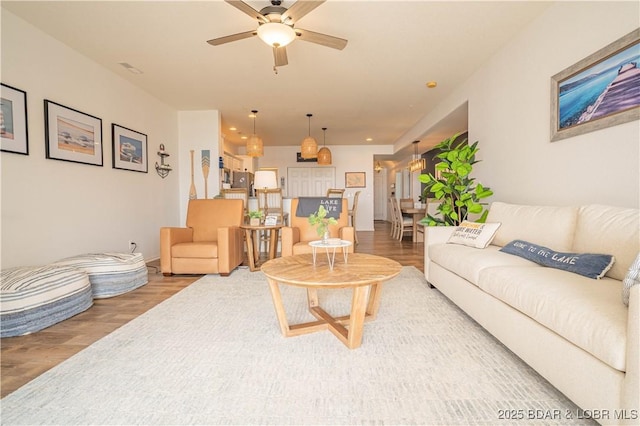 living room with light wood finished floors and ceiling fan