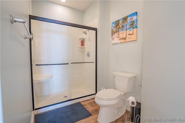 full bath with wood finished floors, a shower stall, and toilet